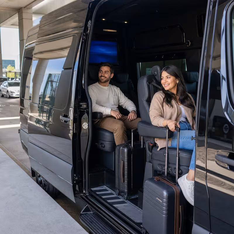 Passengers loading luggage while boarding an Baton Rouge group shuttle