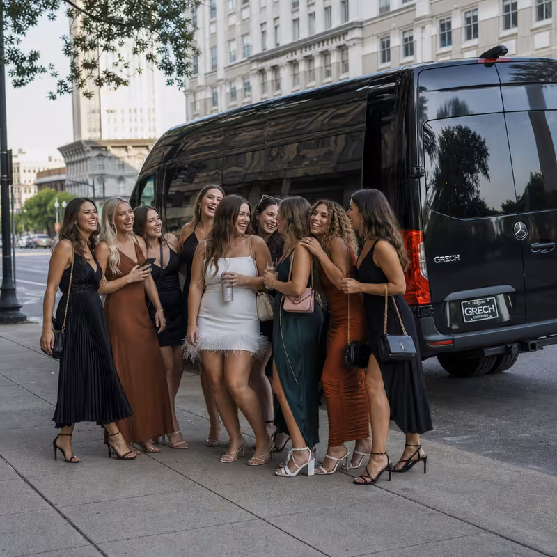 Group boarding a white charter bus for Bachelor & Bachelorette Transportation transportation in Baton Rouge