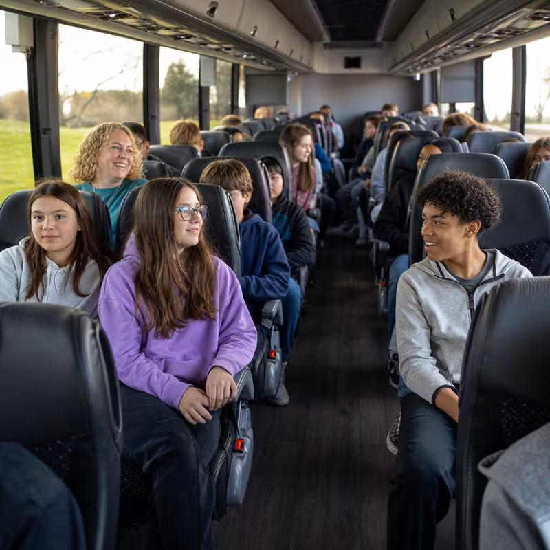 Group boarding a white charter bus for School Transportation transportation in Baton Rouge