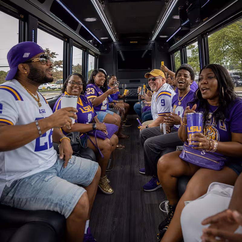 Group boarding a white charter bus for Sporting Event Transportation transportation in Baton Rouge